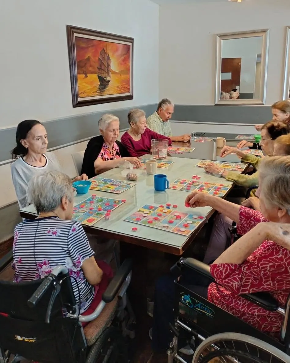 Adultos mayores jugando lotería juntos en Asilo Los Geranios, Chihuahua